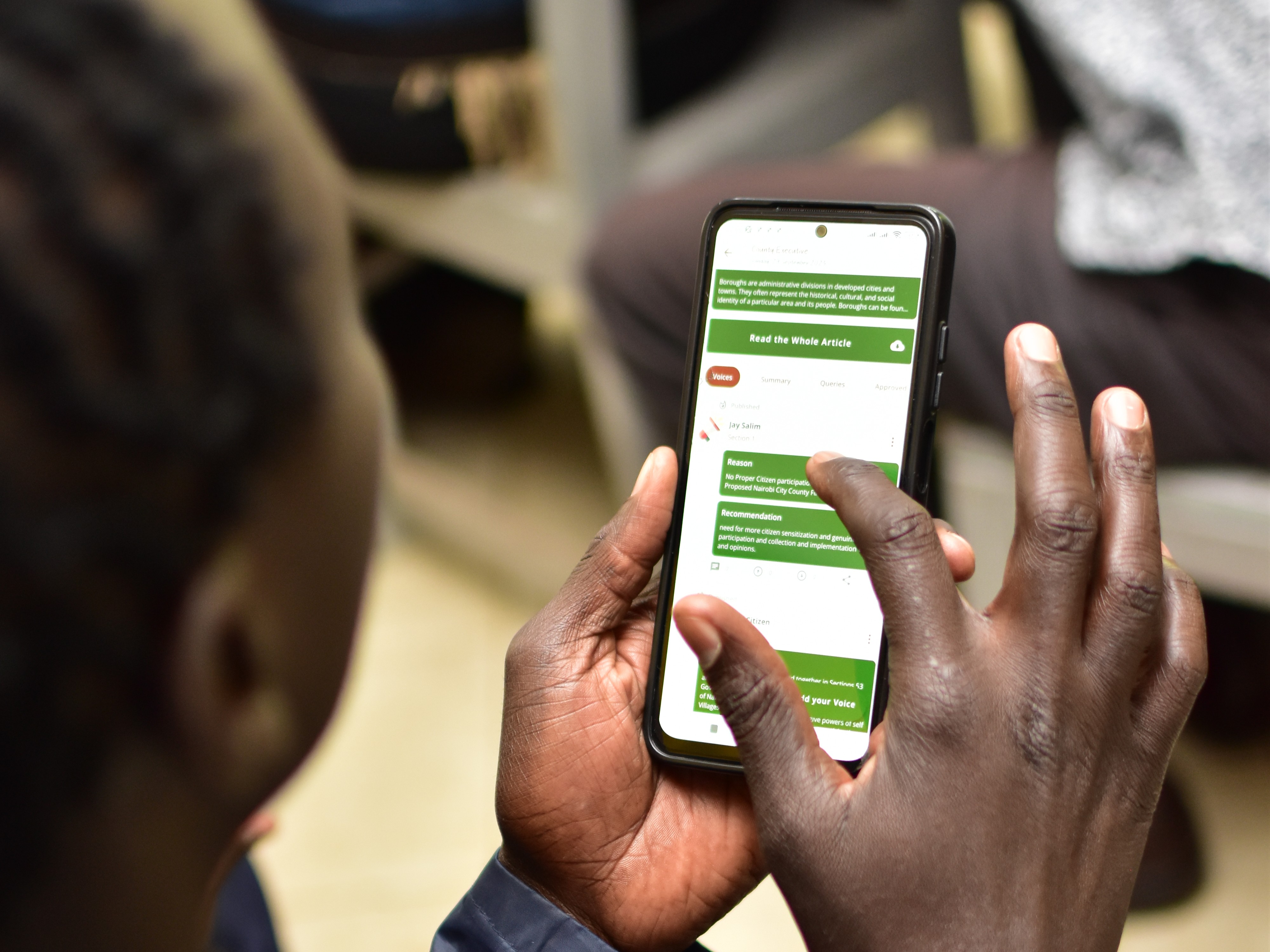 A photorealistic image of a diverse group of people participating in a town hall meeting. The setting is a modern, well-lit community center. The focus is on the engaged expressions of the participants, conveying a sense of active listening and open communication. The color palette is warm and inviting, with a focus on natural tones. The camera angle is a medium shot, capturing the interaction between the participants. Texture details are sharp and realistic, with a focus on the details of the people's clothing and facial expressions. Relevant props include microphones, laptops, and presentation screens. Technical specs: 4K resolution, high quality, photorealistic.